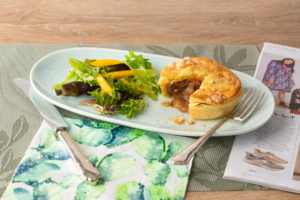 Hub Petite Angus Beef Pie on a plate with salad